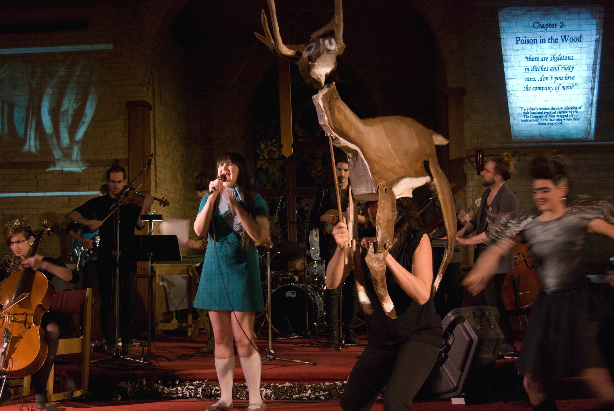 A large ensemble of singers, string players and a life sized deer puppet
