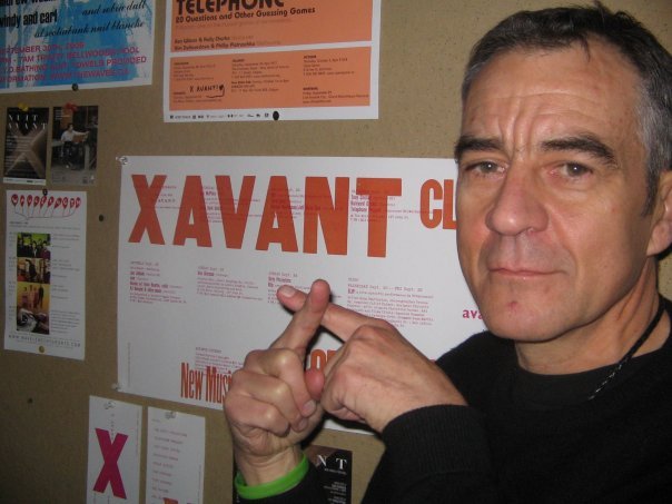 Man makes an X in front of a poster