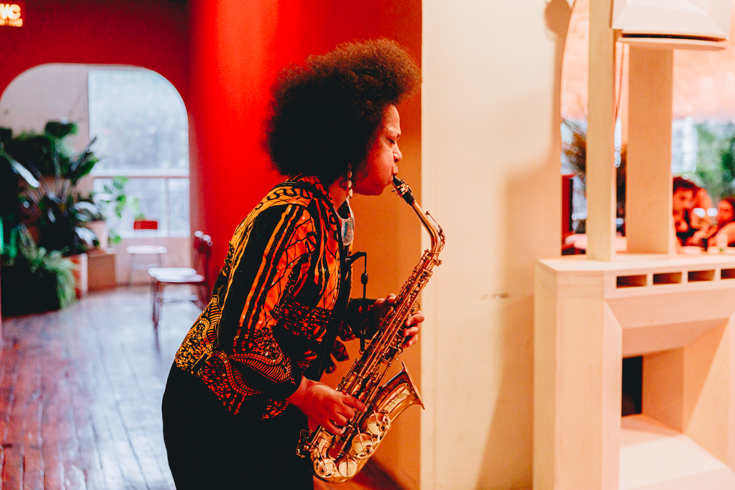 A saxophone player is standing and performing at audience level